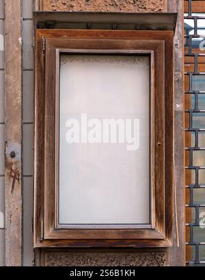 Altes leeres Fenster mit Holzrahmen draußen an einer Fassadenwand Stockfoto