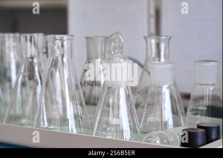 Verschiedene Laborgläser werden auf einem Theken in einem modernen Wissenschaftslabor ausgestellt und zeigen Mess- und Experimentierwerkzeuge Stockfoto