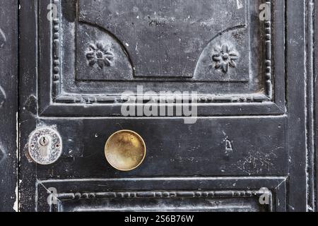 Alte schwarze Holztür mit goldfarbenem Türknauf Stockfoto