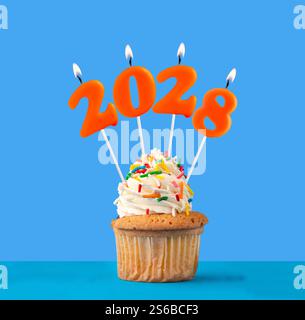 Kerze Nummer 2028 für ein frohes neues Jahr - Silvesterfeier auf blauem Hintergrund Stockfoto