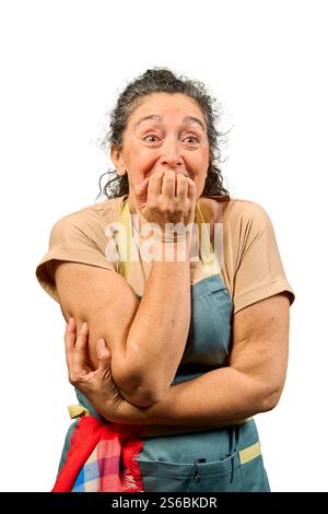 Besorgte reife Frau beißt in die Fingernägel, fühlt sich von Angst und Angst überwältigt und vermittelt ein tiefes Gefühl von emotionaler Not in Innenräumen Stockfoto