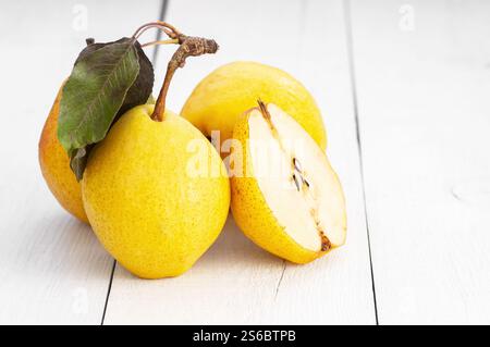 Frische reife gelbe williams Birnenfrüchte auf weißem hölzernem Hintergrund, gesundes Bio-Fruchtkonzept, Nahaufnahme, Kopierraum (Pyrus) Stockfoto