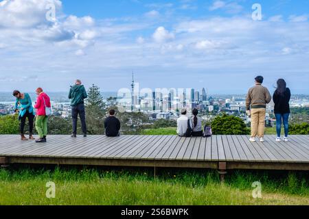 Touristen, Neuseeländer, die die Skyline von Auckland von der Promenade am Mount Eden, dem Skytower, den Gebäuden des zentralen Geschäftsviertels in der Innenstadt, Neuseeland, sehen Stockfoto
