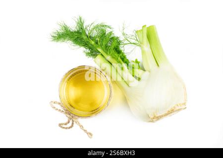 Glasflasche des ätherischen Fenchelöls mit Fenchelsamen und Knolle isoliert auf weißem Hintergrund. Kräuter Alternative Medizin Konzept (Foeniculum vulgare) Stockfoto