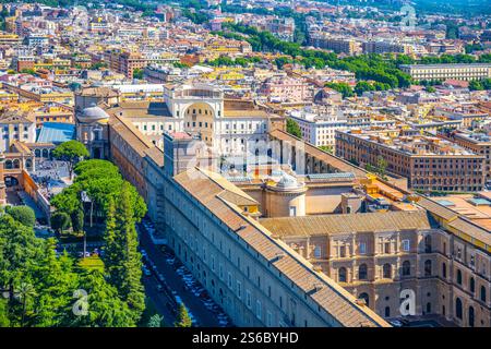 Blick aus der Vogelperspektive auf die Vatikanischen Museen und Gärten in Rom, die komplexe Architektur und üppiges Grün an einem sonnigen Tag hervorheben und die historische Bedeutung des Ortes verdeutlichen. Stockfoto