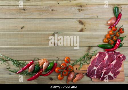 Rohes Rindfleisch, Gemüse auf Holzoberfläche Stockfoto