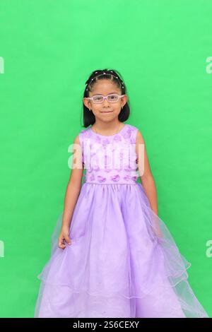 Das 5-jährige lateinische Brünette Mädchen mit Brille und Prinzessinnenkleid ist glücklich und hat Spaß beim Spielen in ihrem Urlaub Stockfoto