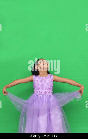 Das 5-jährige lateinische Brünette Mädchen mit Brille und Prinzessinnenkleid ist glücklich und hat Spaß beim Spielen in ihrem Urlaub Stockfoto