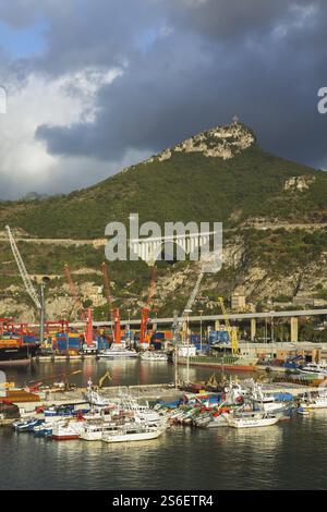 Angedockte Handelsboote sowie gestapelte Frachtcontainer und Ladekräne am Dock im Frachthafen Salerno, Region Kampanien, Italien, Europa Stockfoto