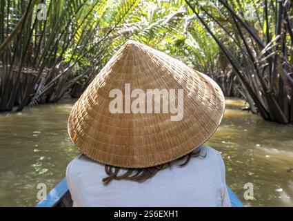 Rückansicht einer Frau mit traditionellem vietnamesischem konischem Hut auf einem Boot, Mekong Delta, Vietnam, Asien Stockfoto