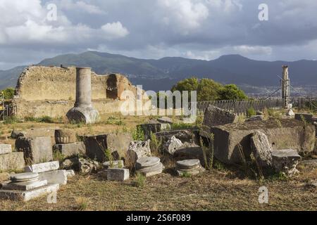 Alte gebrochene Stücke von Marmorsäulen und Platten aus geschnitztem Stein sowie Überreste von Terrakotta-Ziegeln und Steinmauern an den antiken Ruinen von Pompeji Stockfoto