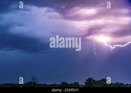 Ein beeindruckendes Gewitter mit hell leuchtendem Blitz vor einem dunklen, dramatischen Himmel, Bogen, Niederbayern Stockfoto