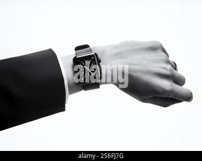 Frau trägt Apple Watch Serie 2 Smartwatch an ihrem Handgelenk, Nahaufnahme von Hand isoliert auf weißem Hintergrund in schwarz / weiß Stockfoto