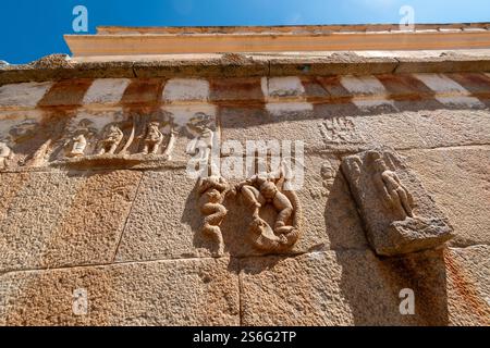 Geschnitzte Symbole mythologischer Gottheiten an den Steinmauern des alten Jain-Tempels auf dem Vindhyagiri-Hügel in Shravanabelagola. Stockfoto