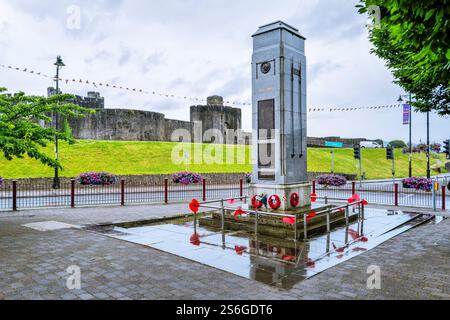 Das Kriegsdenkmal im Caerphilly Town Centre in Südwales Großbritannien. An einem Regentag mit Caerphilly Castle mit Blick auf die Stadt Stockfoto