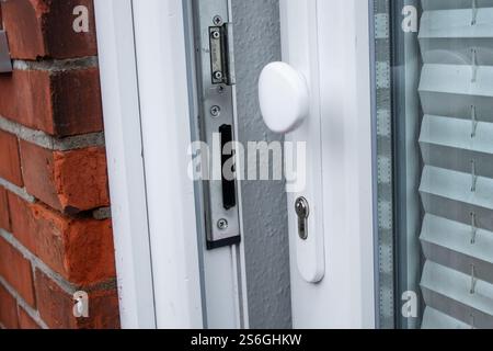 Nahaufnahme einer offenen Eingangstür bei Tageslicht, rote Ziegelsteinmauer Stockfoto