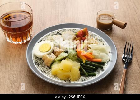 Gado Gado, traditioneller indonesischer Gemüsesalat mit Erdnusssauce, Reiskuchen, Tofu und Ei Stockfoto
