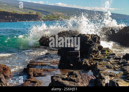 Wellen brechen gegen Lava Rocks an einer tropischen Küste Stockfoto