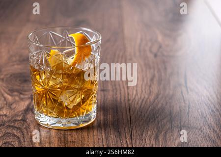 Altmodischer Cocktail garniert mit Orange auf Holztisch Stockfoto