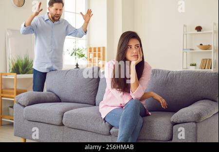 Ein wütender Mann ruft eine Frau an, die sich gleichgültig abwendet Stockfoto