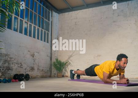 Muskulöser schwarzer Mann, der Plank spielt. Fitness-Workout-Konzept. Stockfoto