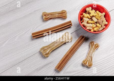 Futter für Hunde. Trockenfutter für Haustiere in einer Schüssel. Granuliertes Tierfutter. Künstliches Hundekauen mit Vitaminen auf dem Boden. Gute Ernährung für Hunde. Stockfoto