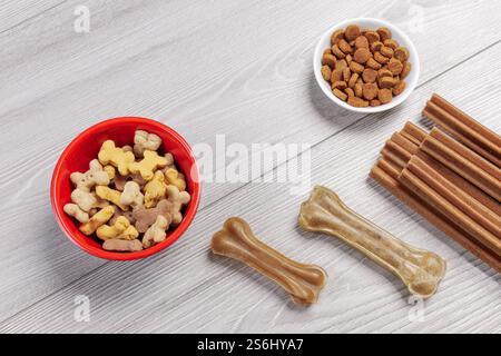 Futter für Hunde. Trockenfutter für Haustiere in Schüsseln. Granuliertes Tierfutter. Künstliches Hundekauen mit Vitaminen auf dem Boden. Gute Ernährung für Hunde. Stockfoto