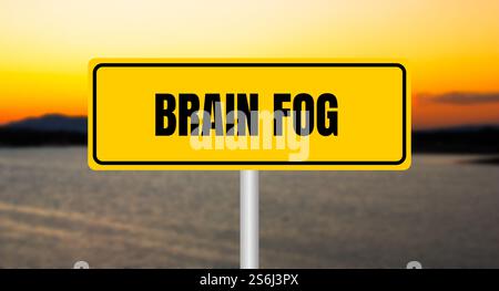 Hirnnebel-Nachricht auf gelbem Schild mit unscharfem See-Hintergrund. Konzeptionelles Hirnnebelsymbol. Kopierbereich. Stockfoto