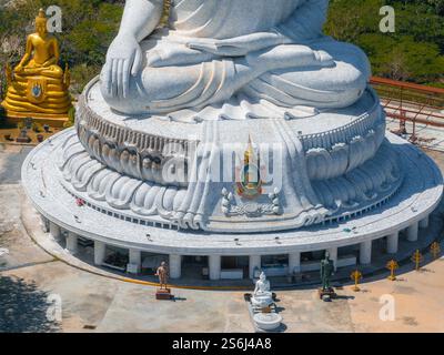 Die Basis der Großen Buddha-Statue in Phuket, Thailand, zeigt komplizierte Details, kleinere Skulpturen, Wege, und üppiges Grün in einer ruhigen Umgebung Stockfoto