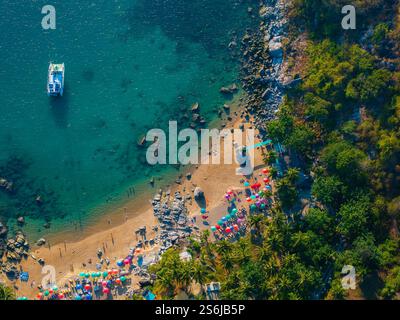 Blick aus der Vogelperspektive auf den lebhaften Strand mit Sonnenschirmen in Phuket, Thailand Stockfoto