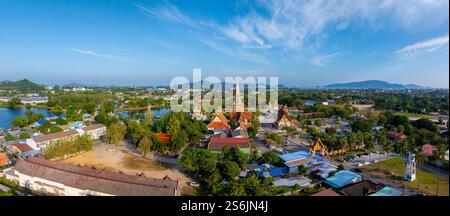 Aus der Vogelperspektive des Tempels Wat Chalong in Phuket, Thailand, mit kunstvoller Architektur, einer majestätischen Pagode, üppigem Grün, und einen ruhigen Teich. Stockfoto