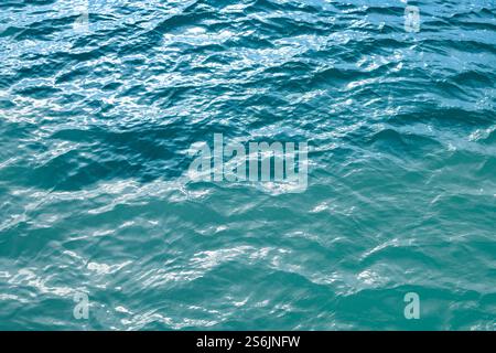 Ozeanoberfläche. Blaue Wasserstruktur. Schließen Sie die blaue Wasseroberfläche. Blick auf die Meeresoberfläche aus der Vogelperspektive. Blaue Meeresoberfläche. Blaues Wasser. Mustertextur Stockfoto