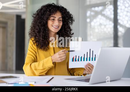 Konferenz zur Online-Geschäftspräsentation. Frau lächelt glücklich und zeigt, wie sie einen Finanzinvestitionsbericht teilt, Diagramm mit Diagrammen. Geschäftsfrau am Arbeitsplatz, die ein Notebook für Videoanrufe verwendet. Stockfoto