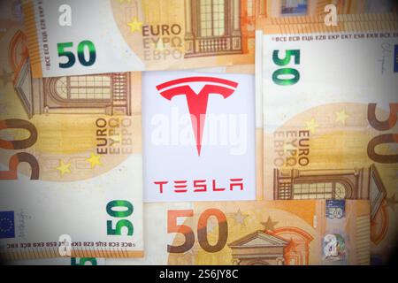 17. Januar 2025, Florenz Italien, auf dieser Fotoabbildung Tesla-Logo mit Euro-Banknoten. Stockfoto