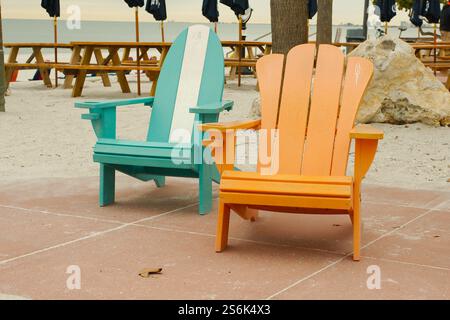 Zwei isolierte blau-weiß-orange Adirondack-Stühle auf dem Pavillon mit Blick auf den Golf von Mexiko in St. Pete Beach, Florida. Blick von Pa Stockfoto