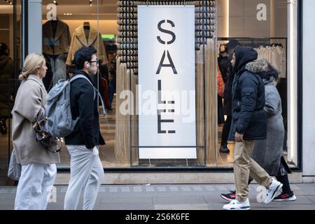 London, Großbritannien. 17. Januar 2025. Shopper auf der Oxford Street passieren Schilder für den jährlichen Winterverkauf im ZARA Store. Das Amt für nationale Statistik (ONS) hat berichtet, dass das Umsatzvolumen im Dezember gegenüber dem Monat um 0,3 % zurückgegangen ist, während das Umsatzwachstum um 0,4 % zu erwarten ist. Die Lebensmittelverkäufe fielen im vergangenen Monat auf das niedrigste Niveau seit mehr als 10 Jahren, aber Bekleidungsgeschäfte und Kaufhäuser verzeichneten einen Anstieg des Handels. Quelle: Stephen Chung / Alamy Live News Stockfoto