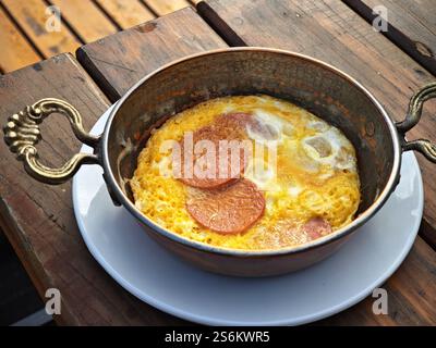 Das traditionelle türkische Gericht Sucuklu menemen, bestehend aus Eiern und Würstchen, wird in einer türkischen Kupferpfanne oder Sahan Tava gekocht Stockfoto