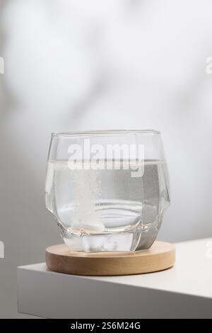 Eine brausende Mukolytika-Tablette löst sich in einem Glas Trinkwasser auf und zeigt ihre schnelle Wirkung beim Abbau von Schleim für eine leichtere Atmungsaktivität Stockfoto