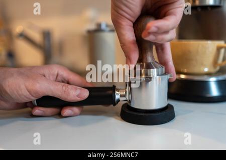 Tamping gemahlener Kaffee: Ein wichtiger Schritt beim Espresso-Aufbrühen Stockfoto
