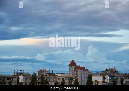 Massive Sturmwolken sammeln sich über der Skyline der Stadt und bilden einen dramatischen Kontrast zwischen dem dunklen, wirbelnden Himmel und den hohen Gebäuden darunter. Die Szene c Stockfoto