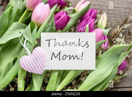 Muttertag-Grußkarte mit rosa und lila Tulpen und Herz Stockfoto