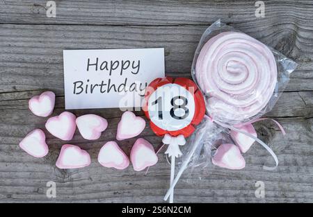 Grußkarte zum 18. Geburtstag und rosa Marshmallows auf Holzbrett Stockfoto
