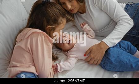 Mutter und Tochter blicken liebevoll auf ein friedlich schlafendes Mädchen in einem gemütlichen Zuhause und verkörpern einen ruhigen Familienmoment voller Wärme und einem Stockfoto