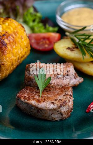 Gegrilltes Schweinefilet auf grünem Teller Stockfoto