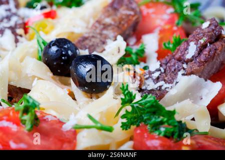 Nahaufnahme frischer Pasta mit Tomaten und Oliven Stockfoto