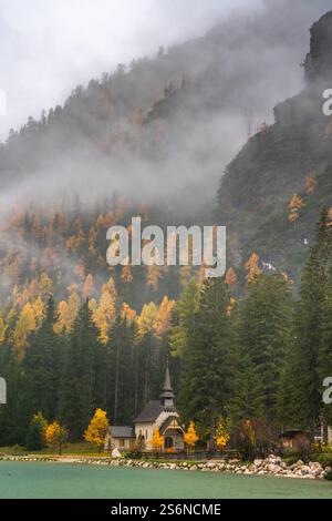 Pragser See mit herbstlicher Laubfarbe und Reflexen in den Dolomiten Italiens, Europa. Stockfoto