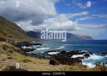 Die zerklüftete Küste auf Oahu, Hawaii, bietet dramatische Klippen, felsige Küsten und das pulsierende blaue Wasser des Pazifischen Ozeans unter einem teilweise bewölkten Himmel Stockfoto