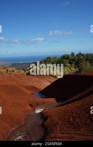 Red Dirt Falls auf Kauai, Hawaii, mit leuchtenden roten Sandformationen und einem kleinen kaskadierenden Bach, der die einzigartige geologische Schönheit der Insel zeigt. Stockfoto