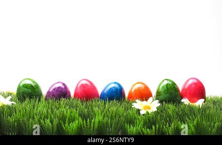 Bunte Ostereier in Folge auf dem Rasen auf einem weißen Hintergrund Stockfoto