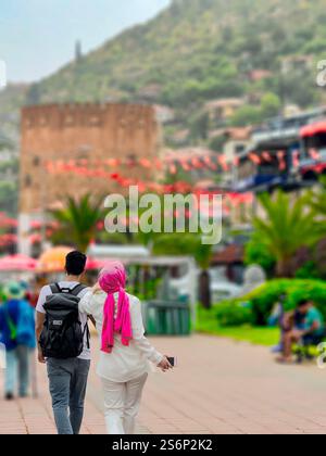 Ein paar Spaziergänge Hand in Hand entlang der Promenade in Richtung der Festung von Alanya in der Türkei Stockfoto